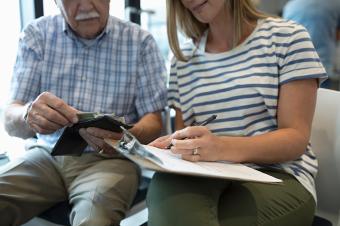 woman helps her older father complete health insurance forms  