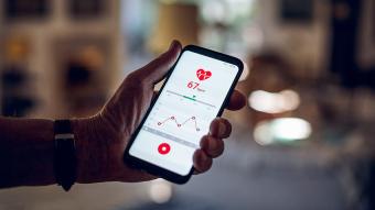 A person holding a phone with a health app on the screen