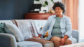 An older woman sitting alone on a couch