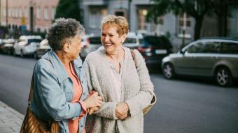 two older women walking arm in arm 