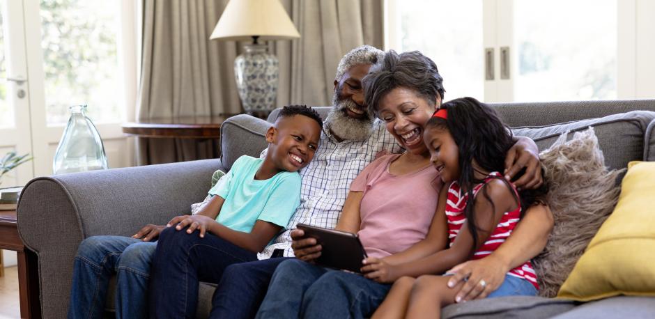 Senior couple cuddling grandkids